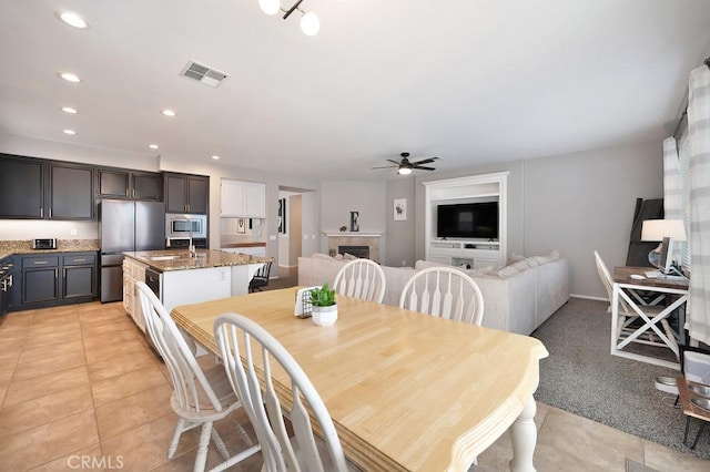 dining area featuring light tile patterned floors, recessed lighting, a fireplace, visible vents, and a ceiling fan