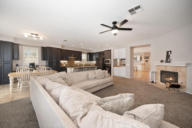 living area with light colored carpet, recessed lighting, a fireplace, a ceiling fan, and visible vents