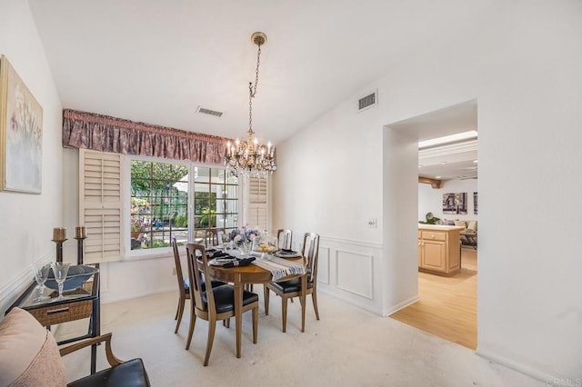 dining area with wainscoting, visible vents, a decorative wall, and an inviting chandelier