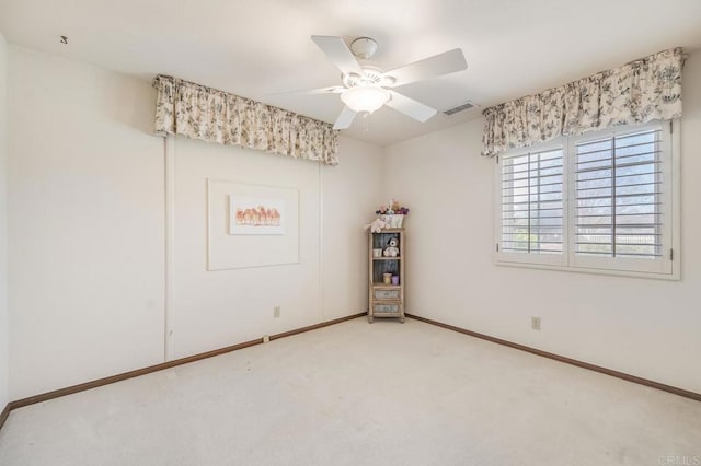 empty room featuring carpet floors, a ceiling fan, visible vents, and baseboards