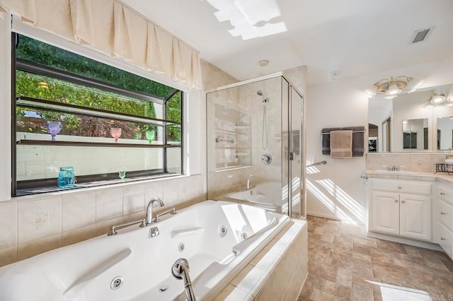 bathroom featuring visible vents, decorative backsplash, a stall shower, vanity, and a jetted tub