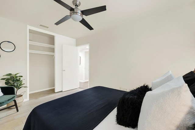 bedroom featuring light wood finished floors, baseboards, visible vents, and a ceiling fan