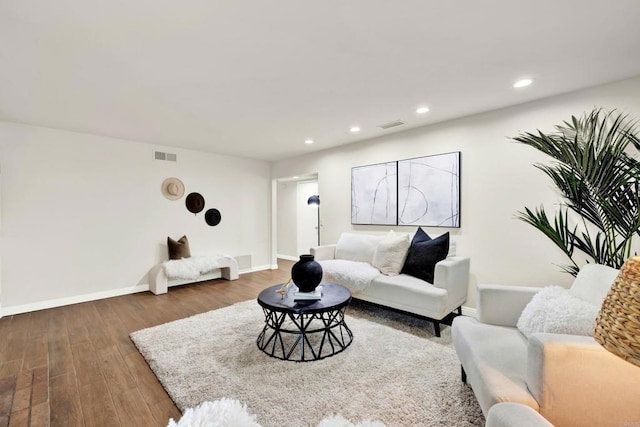 living area with recessed lighting, visible vents, baseboards, and wood finished floors