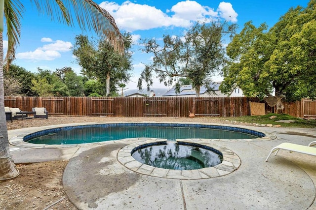 view of pool with a patio area, a fenced backyard, a fenced in pool, and an in ground hot tub