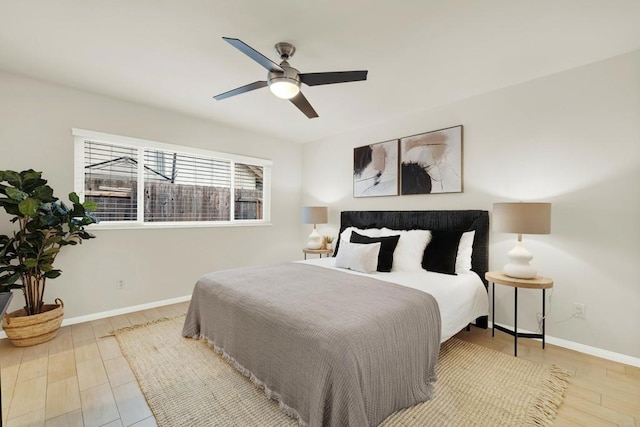 bedroom with ceiling fan, wood finished floors, and baseboards