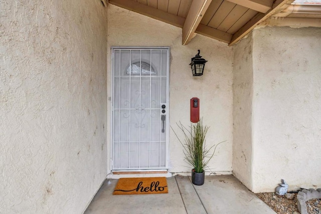 entrance to property featuring stucco siding