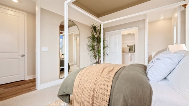 bedroom featuring arched walkways, a closet, and baseboards