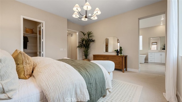 bedroom with light colored carpet, a spacious closet, ensuite bathroom, a chandelier, and baseboards