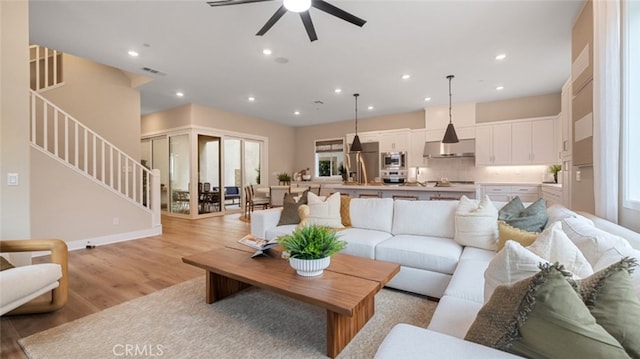 living area with light wood finished floors, stairway, visible vents, and recessed lighting