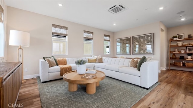 living area with recessed lighting, baseboards, visible vents, and light wood finished floors