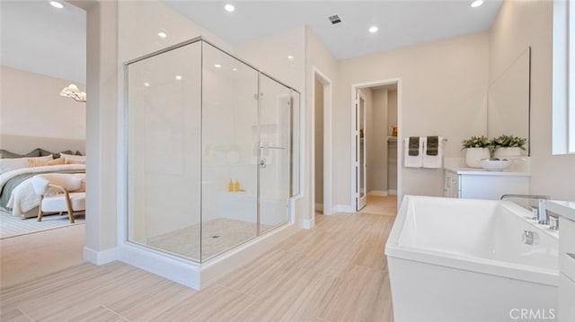 ensuite bathroom with ensuite bathroom, recessed lighting, visible vents, a freestanding bath, and a shower stall