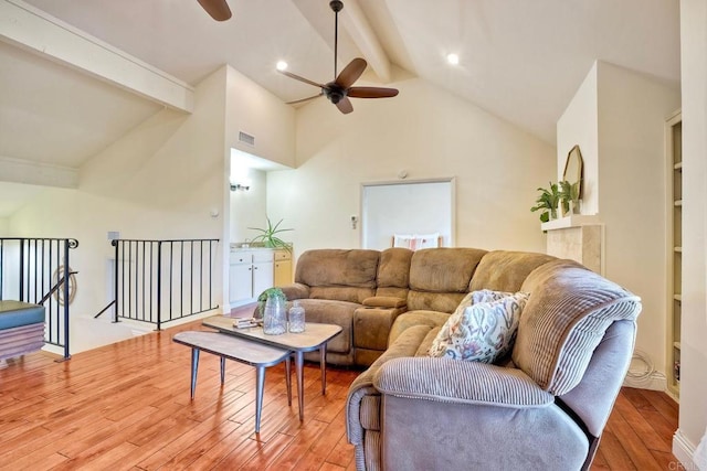 living room featuring ceiling fan, hardwood / wood-style floors, beamed ceiling, and visible vents