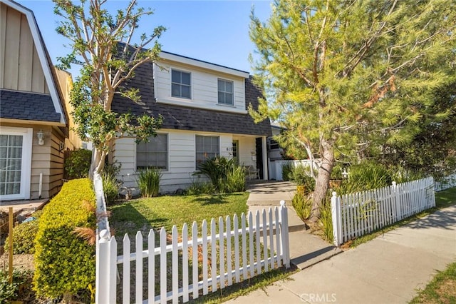 view of front of property with a fenced front yard and a shingled roof