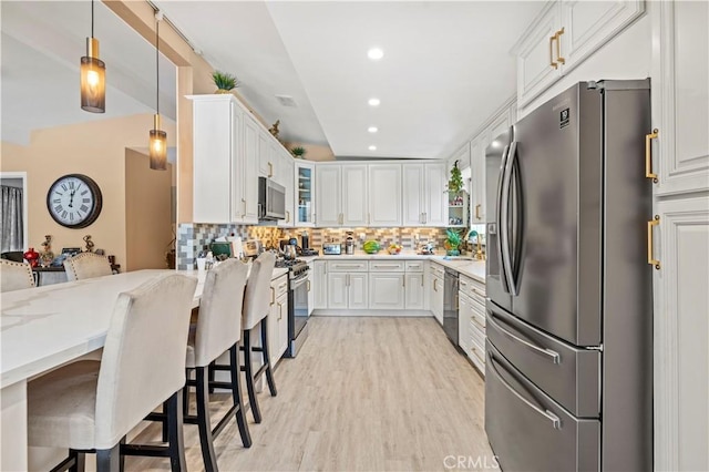 kitchen with stainless steel appliances, glass insert cabinets, a sink, and backsplash