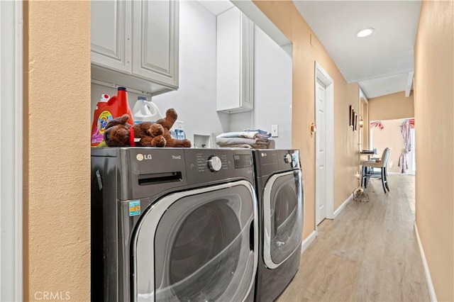 laundry room featuring cabinet space, baseboards, washer and clothes dryer, light wood-type flooring, and recessed lighting