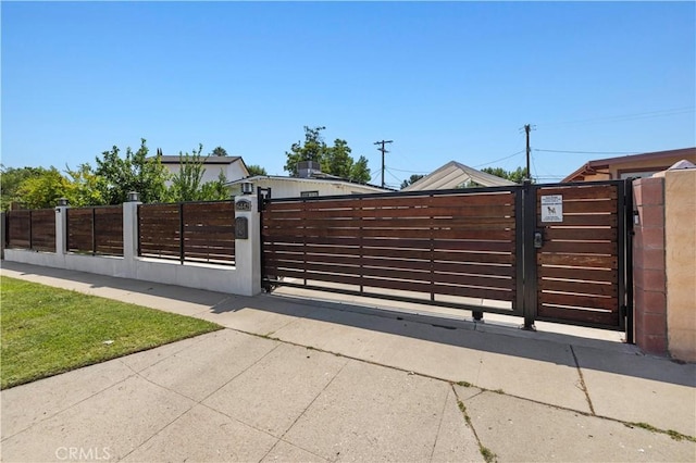 view of gate with a fenced front yard