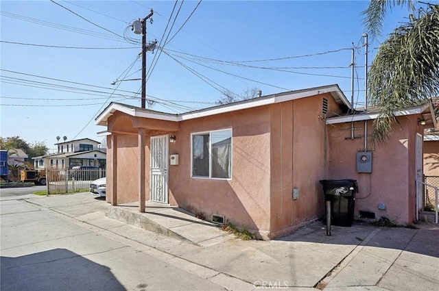 view of front of home featuring fence and stucco siding