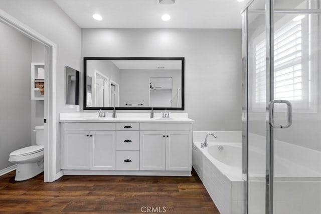 full bathroom featuring wood finished floors, a sink, and a bath