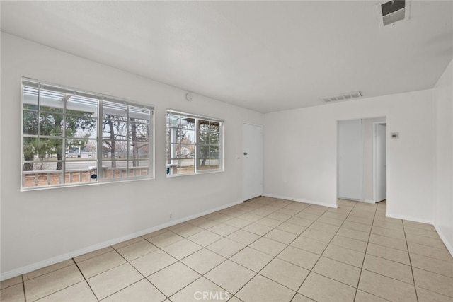 unfurnished room with light tile patterned floors, visible vents, and baseboards