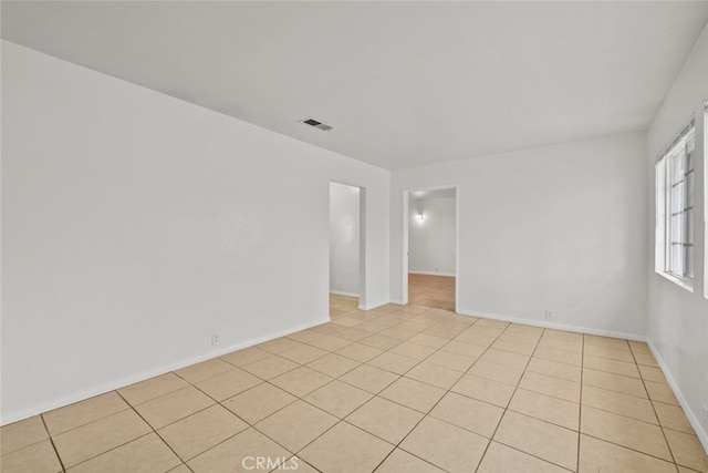 unfurnished room with baseboards and light tile patterned floors