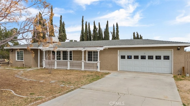 ranch-style house with a garage, covered porch, driveway, and stucco siding