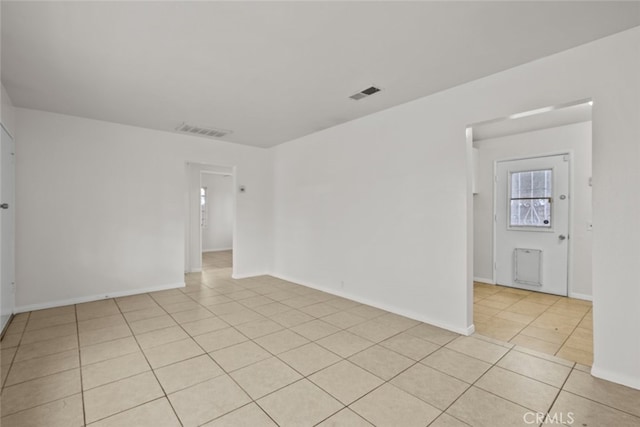 unfurnished room with light tile patterned floors, baseboards, and visible vents