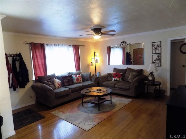 living room featuring a ceiling fan, baseboards, ornamental molding, and wood finished floors