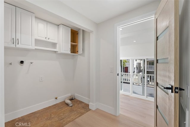 washroom featuring cabinet space, light wood-style flooring, and baseboards