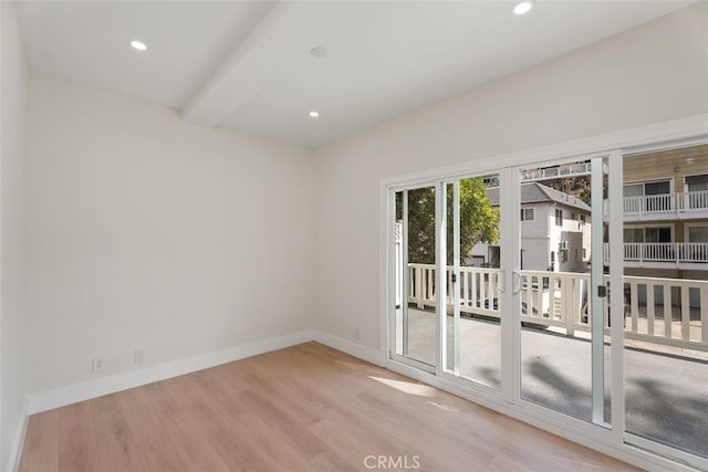 spare room with recessed lighting, wood finished floors, beam ceiling, and baseboards