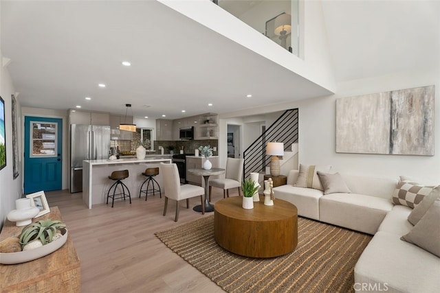 living room featuring recessed lighting, stairway, and light wood finished floors