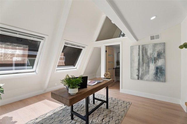 office area featuring baseboards, visible vents, vaulted ceiling, and light wood finished floors