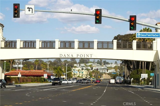 view of street with traffic lights, street lights, traffic signs, sidewalks, and curbs