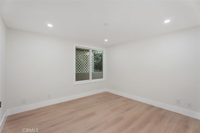 unfurnished room featuring light wood finished floors, recessed lighting, and baseboards