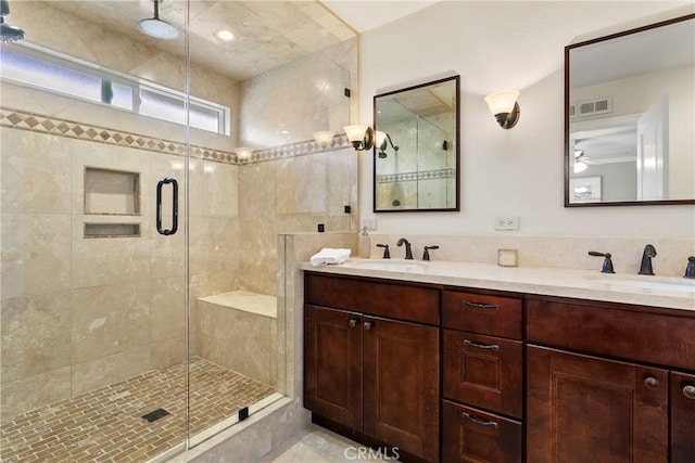 full bathroom featuring double vanity, a stall shower, a sink, and visible vents