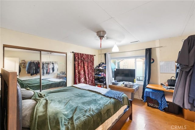 bedroom featuring a closet, wood finished floors, and a ceiling fan