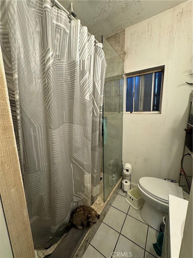 bathroom with curtained shower, toilet, and tile patterned floors