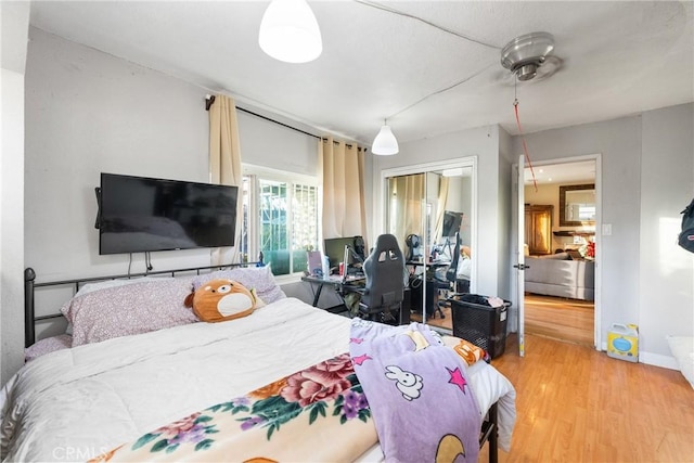 bedroom featuring a closet, baseboards, and light wood finished floors