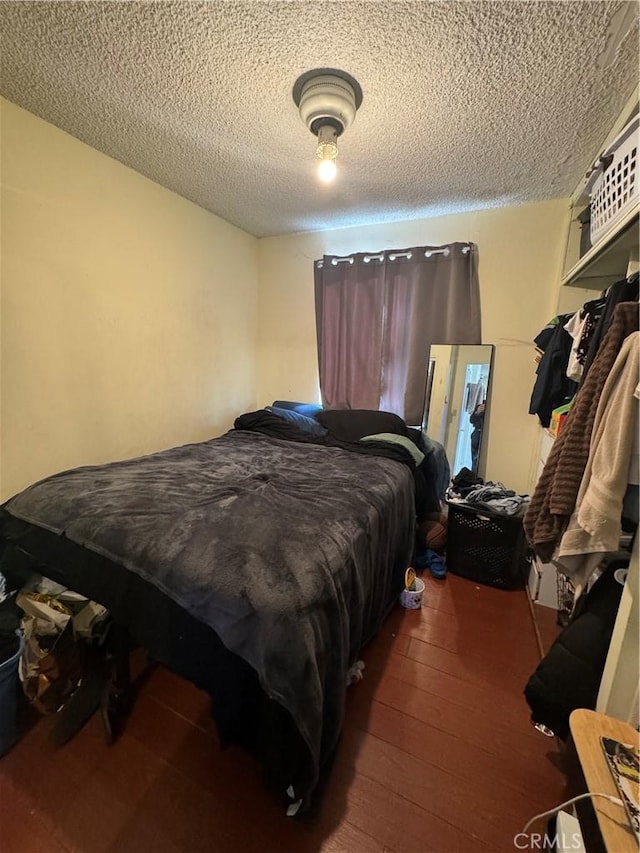 bedroom with a textured ceiling and hardwood / wood-style floors