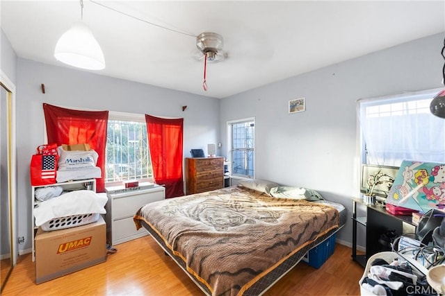 bedroom featuring a ceiling fan, baseboards, and wood finished floors