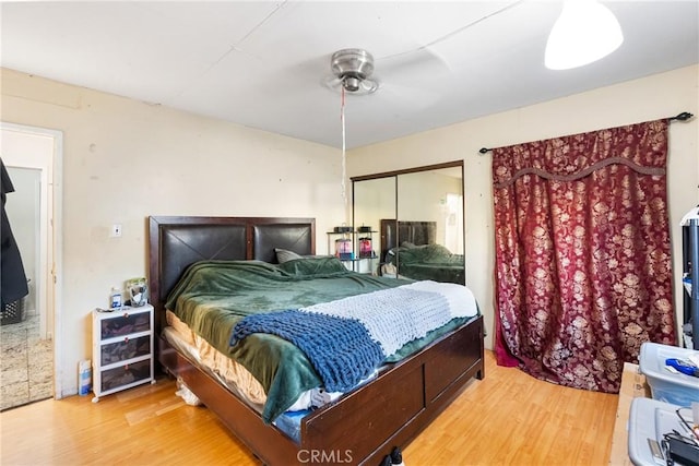 bedroom with a ceiling fan, a closet, and wood finished floors