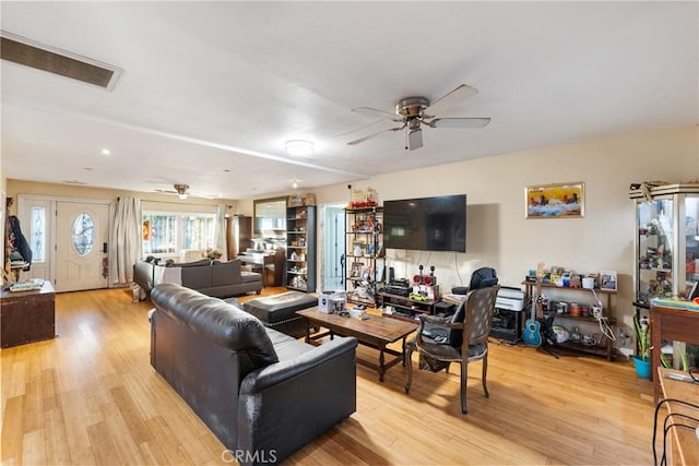 living area with light wood finished floors, visible vents, and a ceiling fan