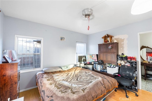 bedroom with light wood-type flooring and baseboards