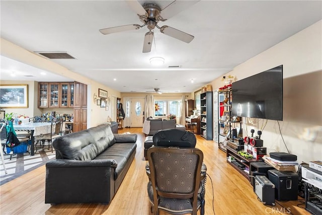 living area with ceiling fan, light wood finished floors, and visible vents