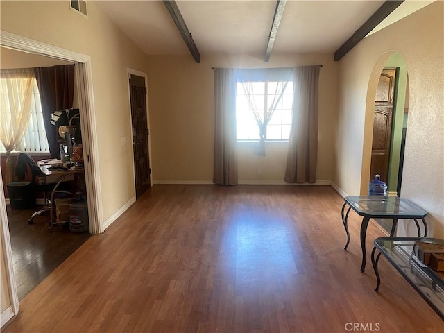 3158 E E Ave H8, Lancaster, CA 93535 - unfurnished room featuring beam ceiling, wood finished floors, arched walkways, an office area, and baseboards