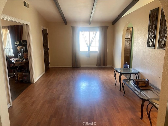 3158 E E Ave H8, Lancaster, CA 93535 - empty room with arched walkways, wood finished floors, a desk, and baseboards