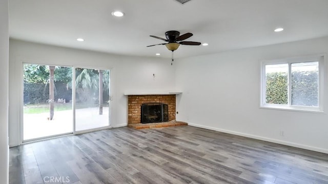 unfurnished living room with a fireplace, baseboards, wood finished floors, and recessed lighting