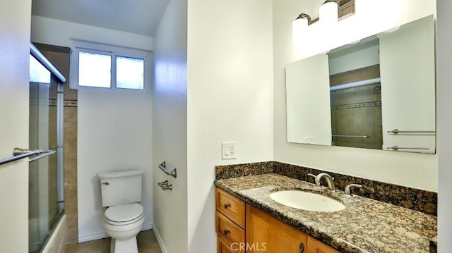 full bathroom with enclosed tub / shower combo, vanity, toilet, and baseboards