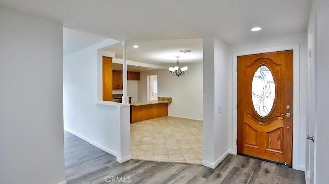 foyer entrance with a notable chandelier, visible vents, wood finished floors, and recessed lighting