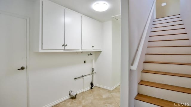 laundry area with cabinet space, baseboards, and electric dryer hookup