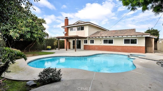 view of swimming pool featuring a patio area, a pool with connected hot tub, and fence